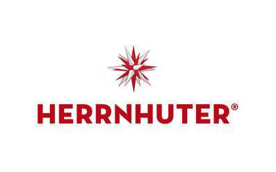 Das Logo von Herrnhuter zeigt den markanten roten Schriftzug ‚HERRNHUTER‘ mit einem stilisierten Herrnhuter Stern darüber