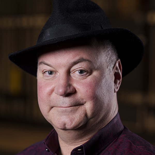 Porträt von Hans-Peter Struppe mit schwarzem Hut und dunklem Hemd